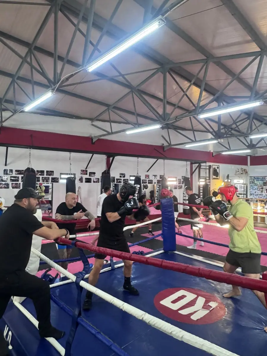 Midnight Mayhem fighters sparring in the ring in Lisbon, with coaches watching from the ropes