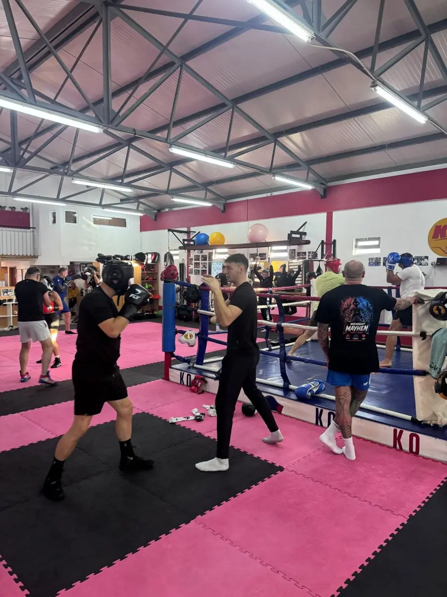 Pad work and sparring on the gym floor during the final morning session