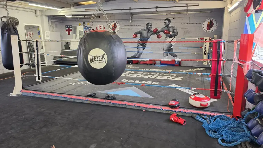 A boxing ring with a bag hanging in the foreground