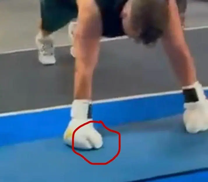 A gloved hand on the mat with the thumb circled