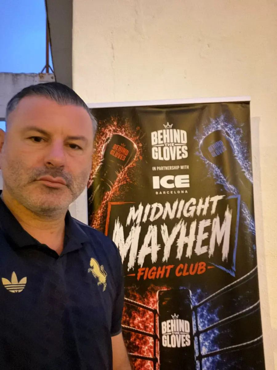 Jon Arnold in front of a Midnight Mayhem banner