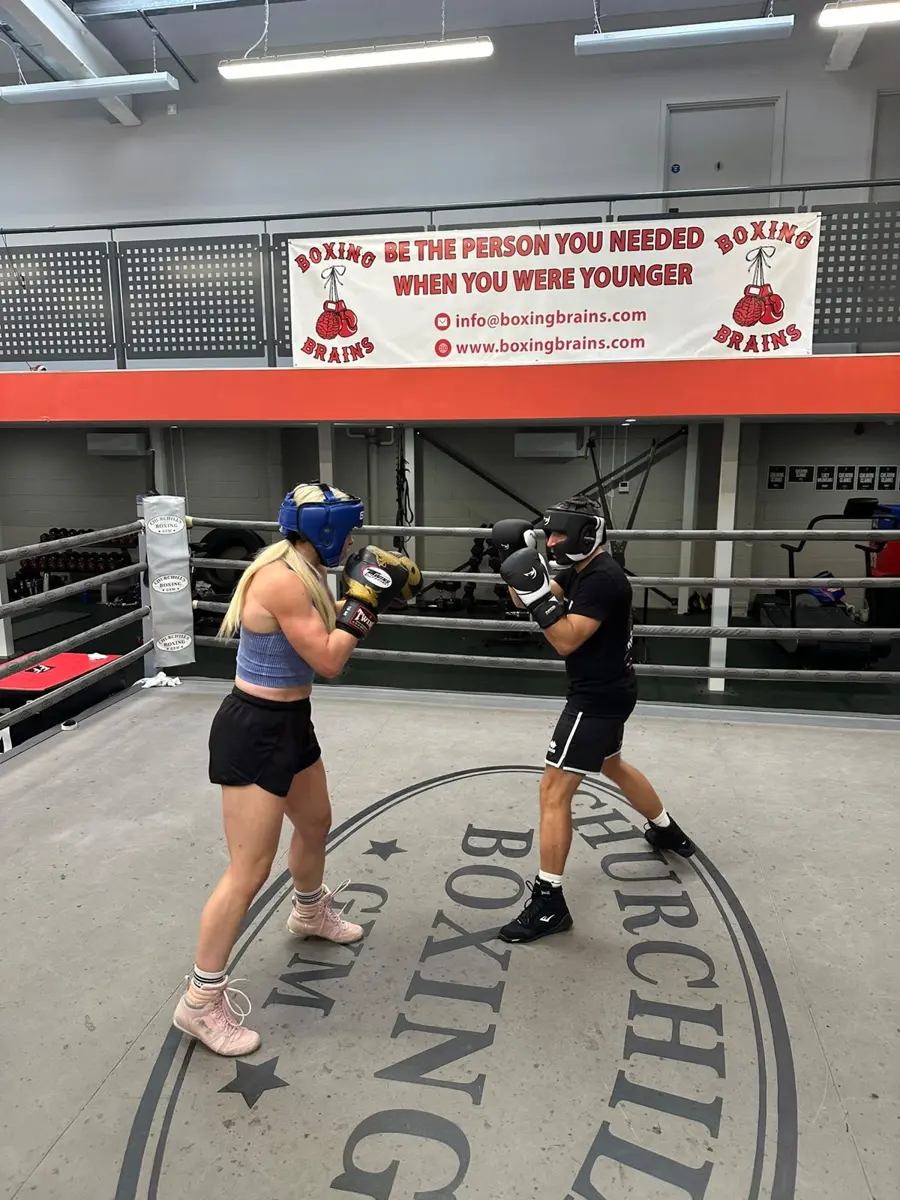 Two fighters in head guards sparring