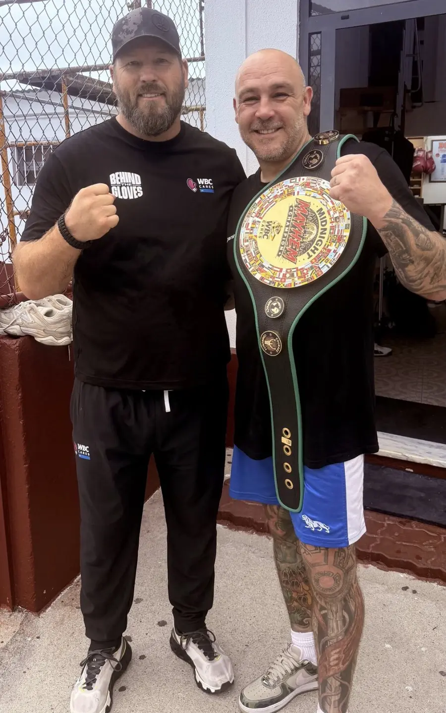 Scott Welch of WBC Cares UK and Lee McFarland of Behind The Gloves outside the gym, Lee holding the Midnight Mayhem Champion belt