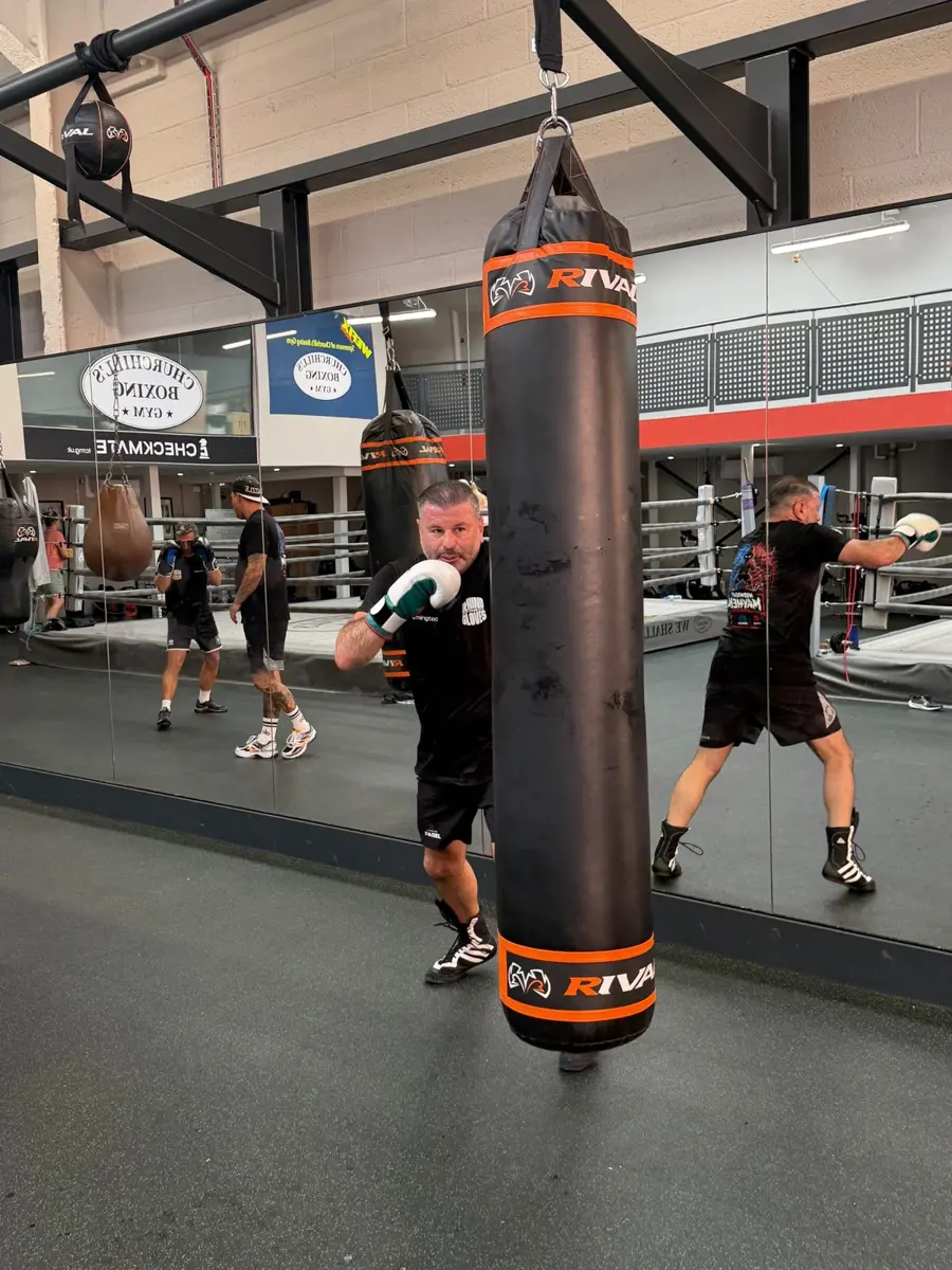 Heavy bag work in front of the gym mirrors