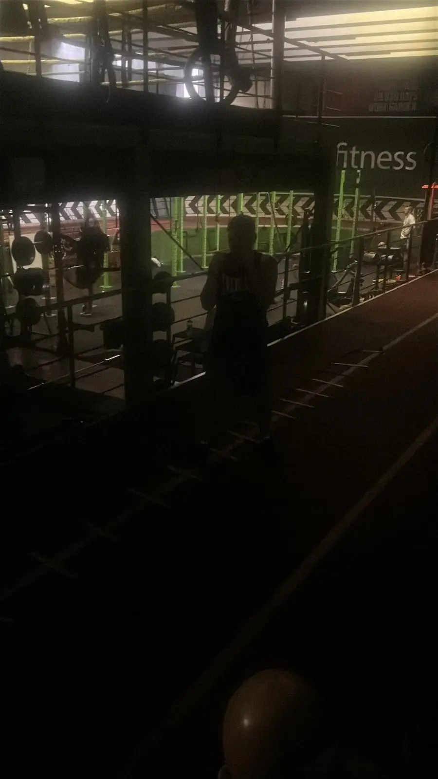 A fighter training in a gym lit only by emergency lights